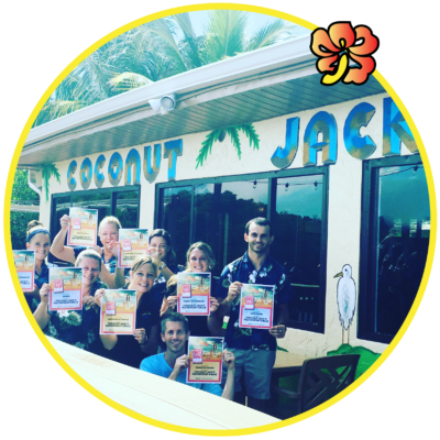 A group of people holding up boxes in front of a restaurant.