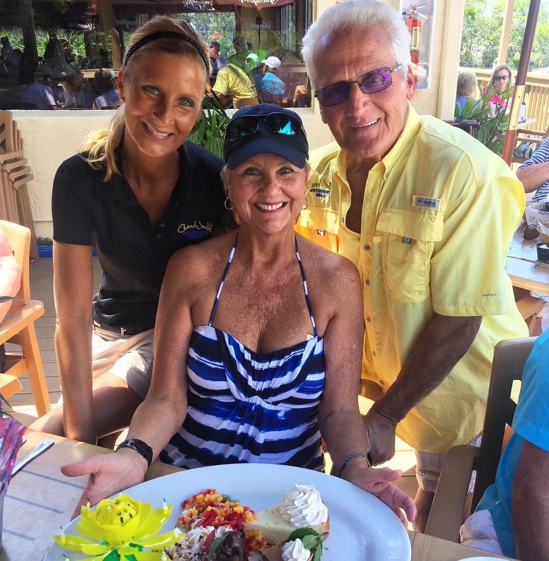 A group of people posing for the camera at an outdoor restaurant.
