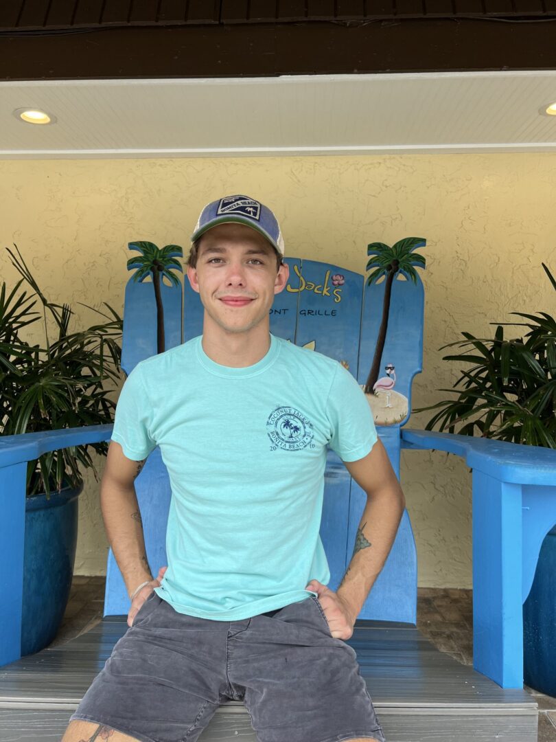 A young man in a blue shirt and hat.