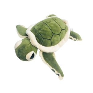A stuffed turtle is laying down on the ground.