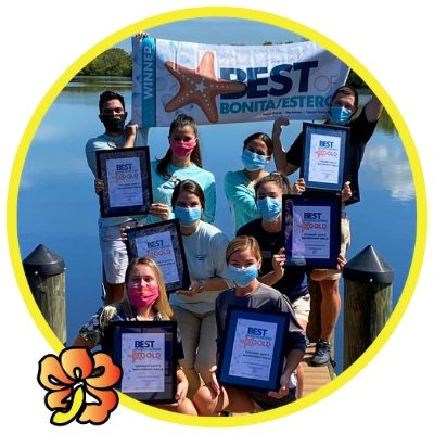 A group of people holding certificates in front of water.
