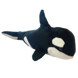 A stuffed orca whale laying down on top of the ground.