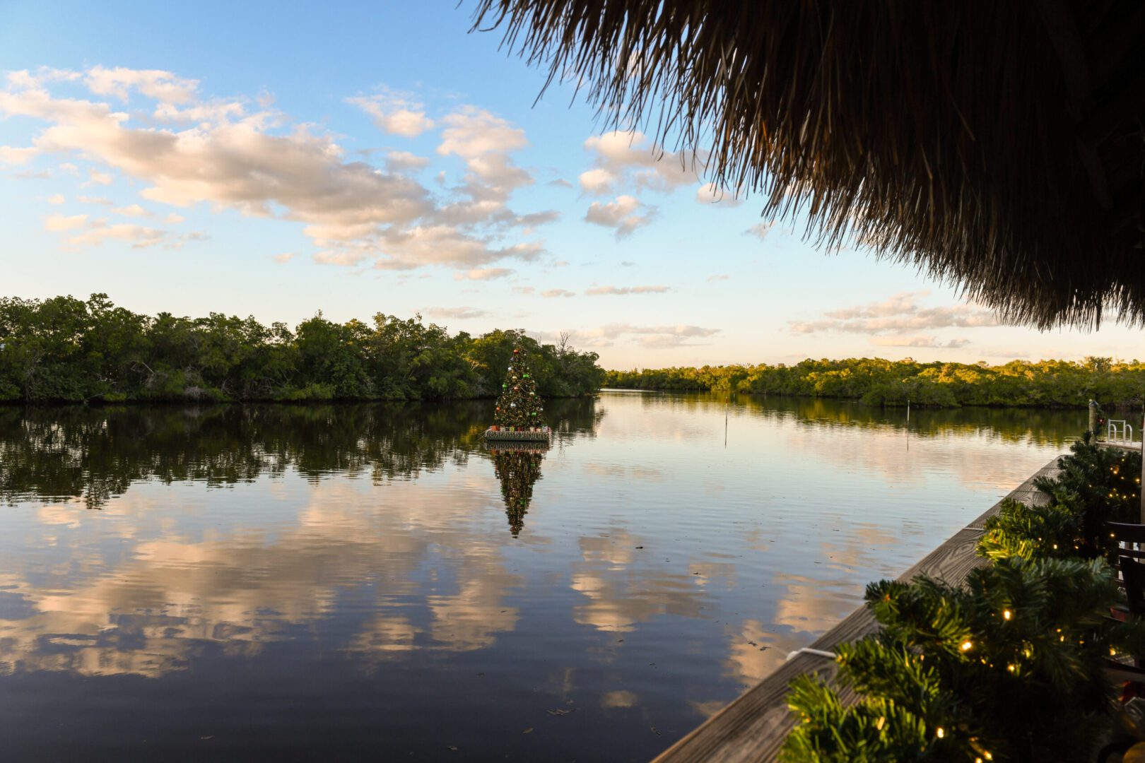 A boat is sailing on the water near some trees.