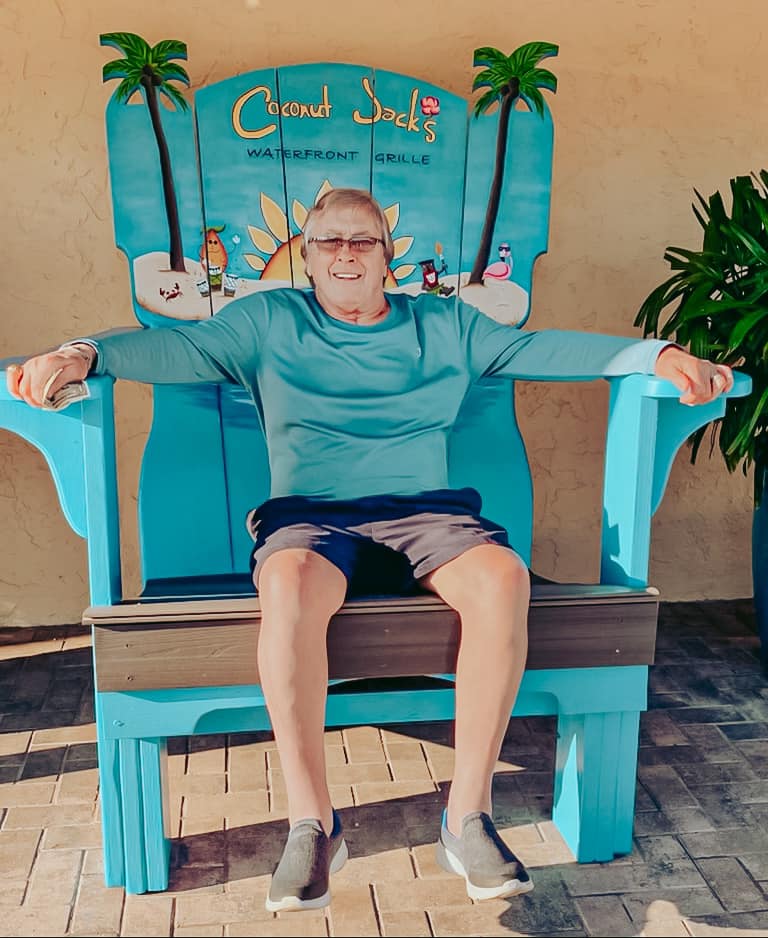 A man sitting on top of a blue chair.