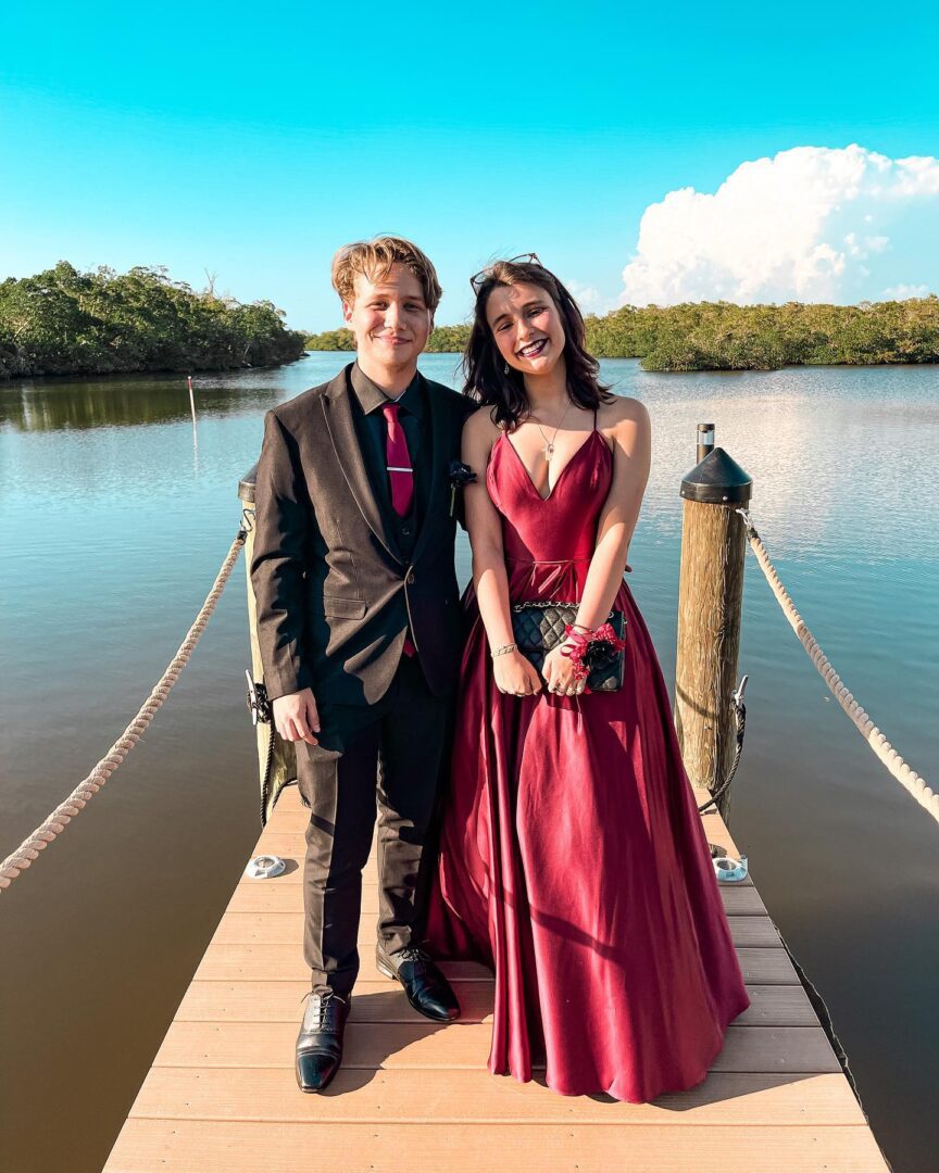 A couple of people standing on top of a dock.