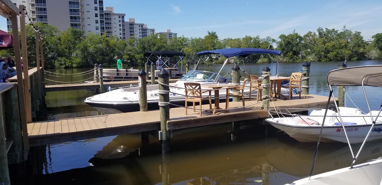 A boat dock with chairs and tables on the water.