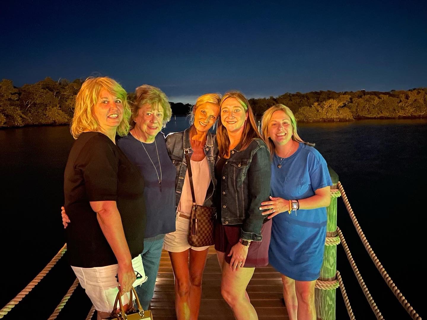 A group of women standing on the end of a pier.