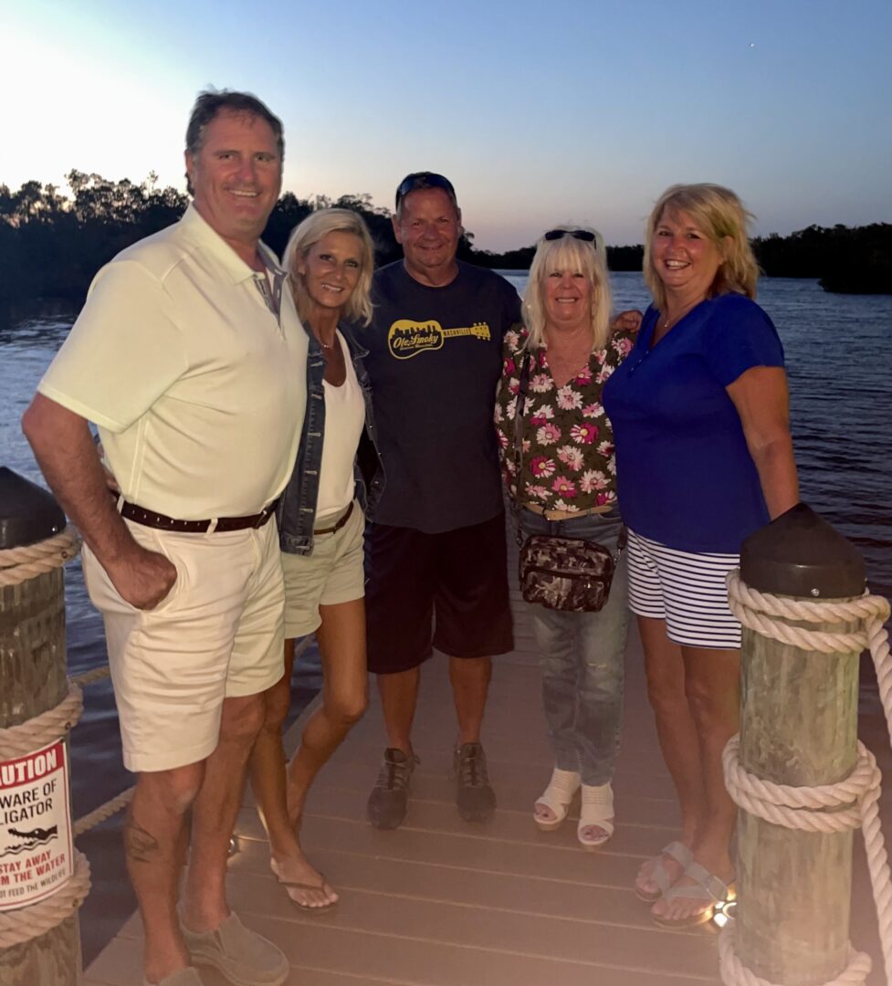 A group of people standing on the side of a boat.