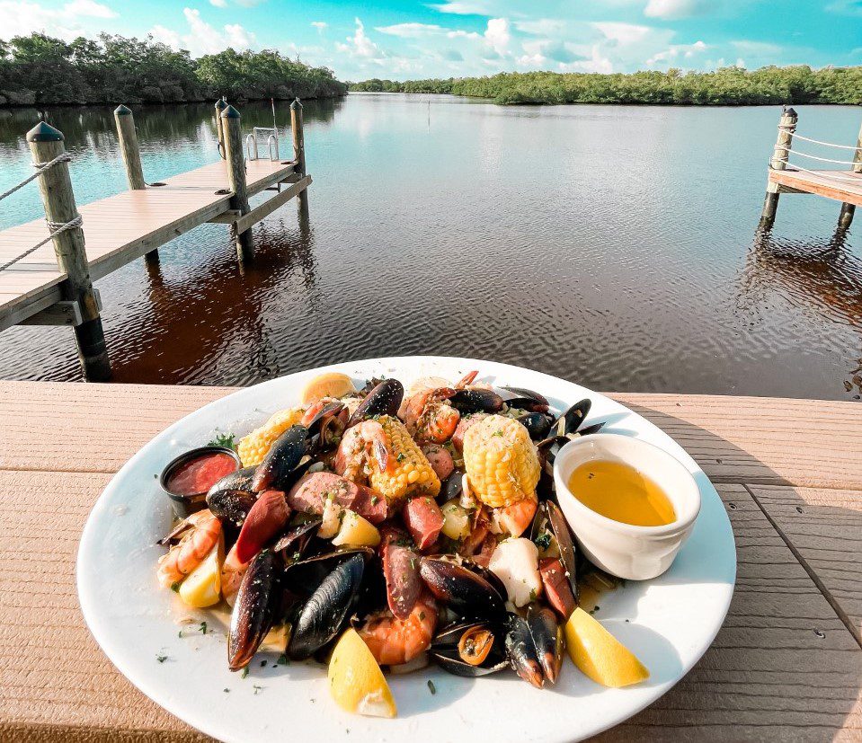 A plate of food on the table near water.