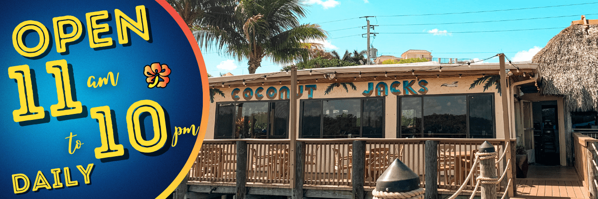 A restaurant with palm trees and a sign on the side.