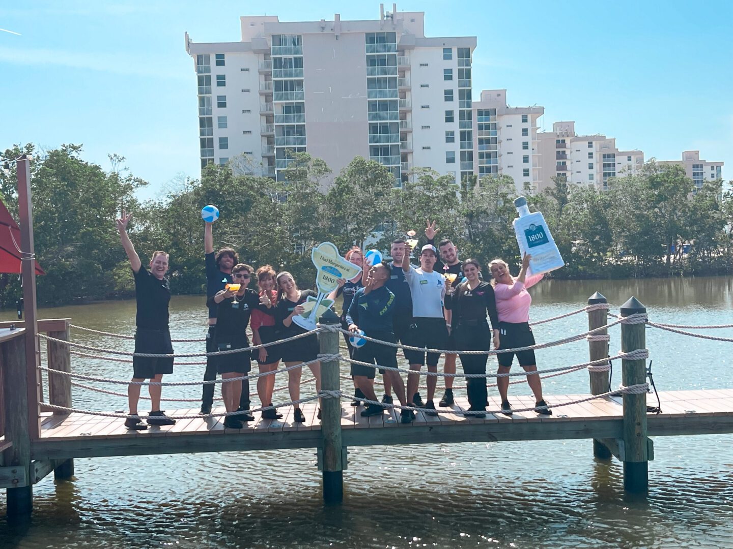 A group of people standing on top of a wooden pier.