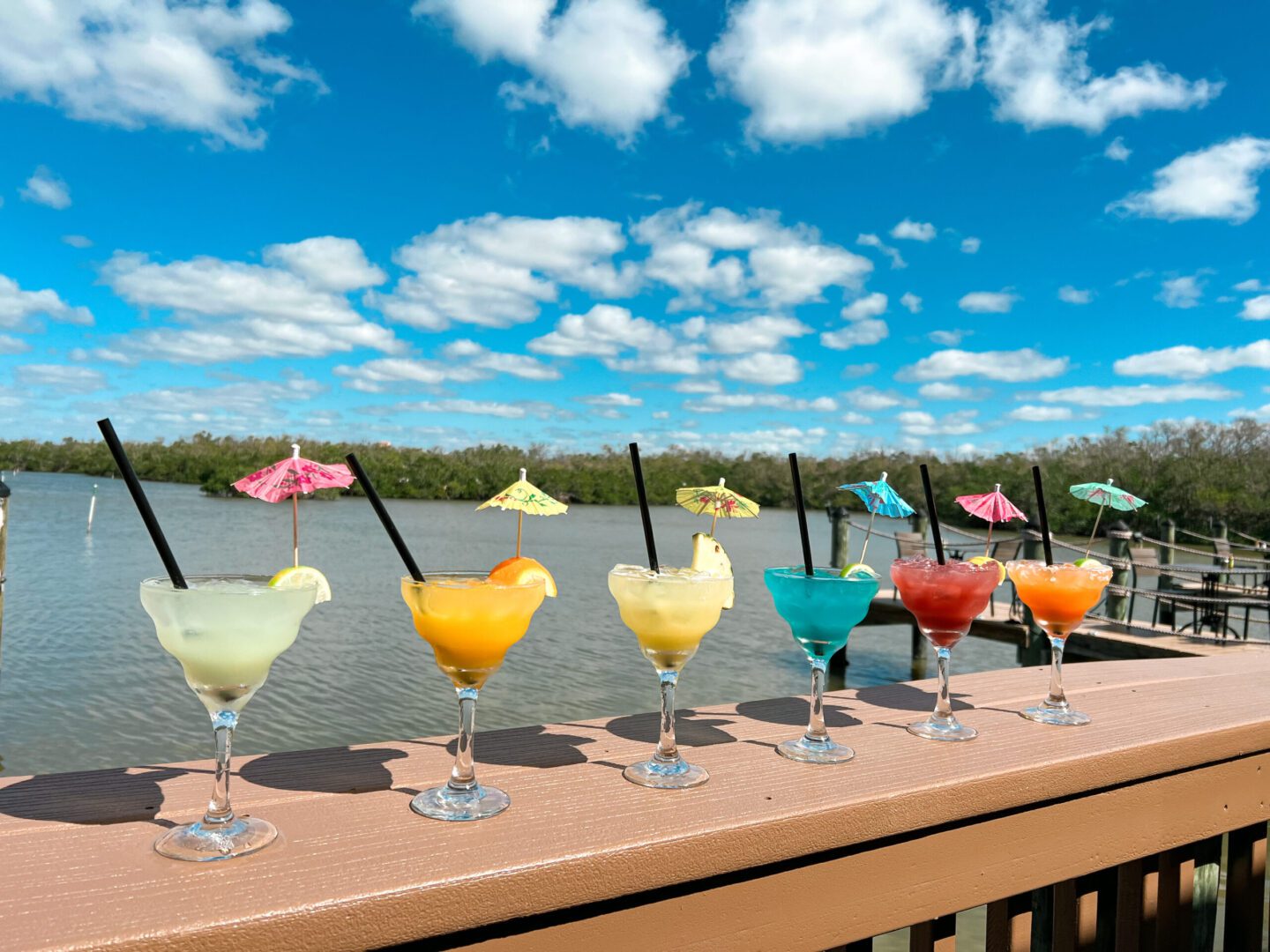 A row of colorful drinks on the side of a river.