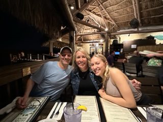 Three people sitting at a table with drinks.