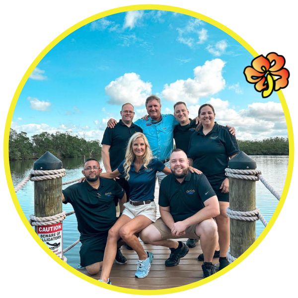 A group of people posing for the camera on a dock.