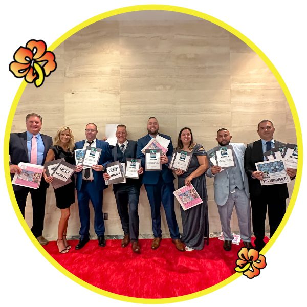 A group of people holding up certificates in front of a red carpet.