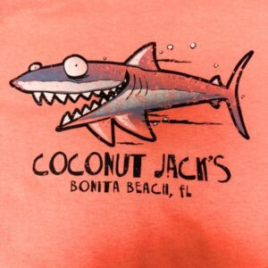 A close up of the front of a t shirt with a shark