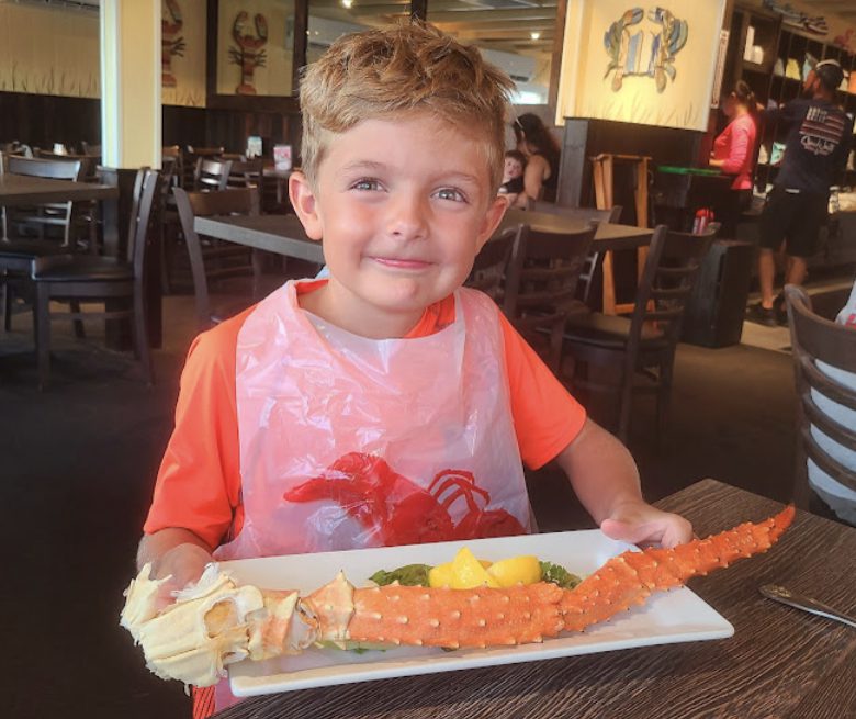 A young boy holding a plate of food.