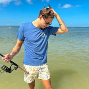 A man holding a fishing rod in the water.
