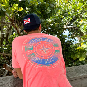 A man wearing a hat and shirt sitting on a bench.