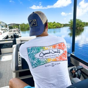 A man sitting on the back of a boat in the water.