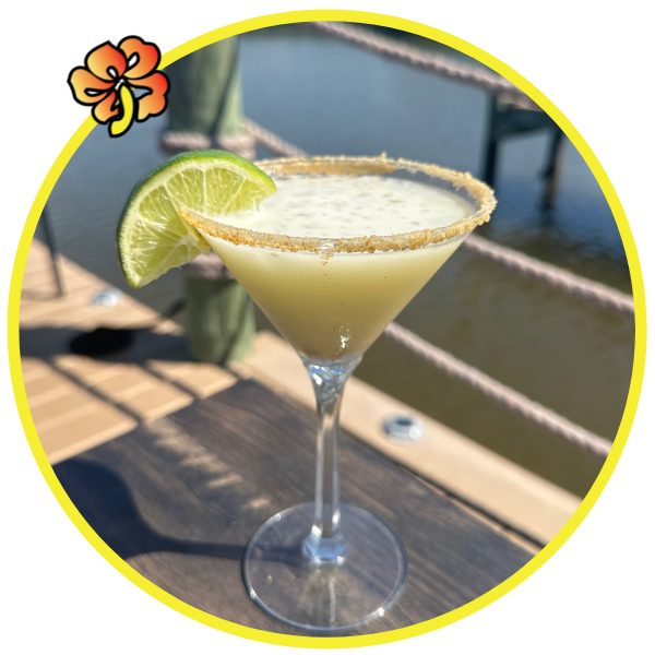 Cocktail with lime slice by the water.